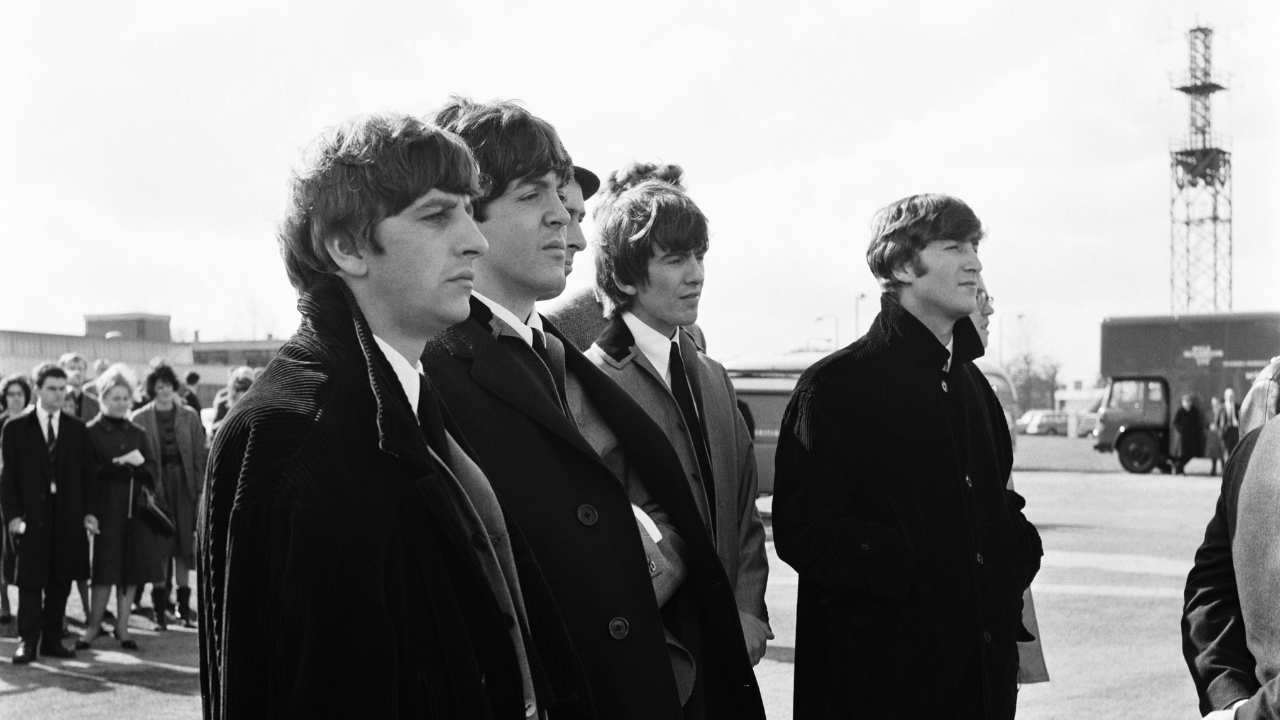 side profile of The Beatles standing together